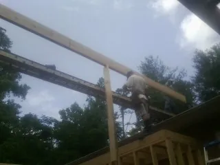 Carpenter setting a ridge beam over a new addition frame — Ice Dam Removal by Roofing Brothers in Orofino