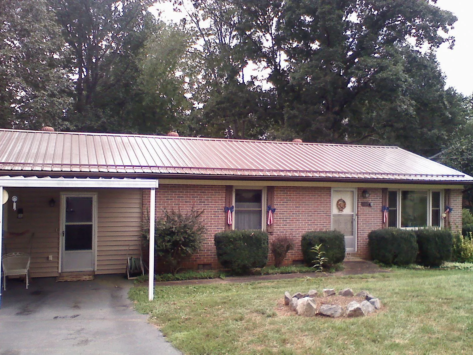 Bronze metal roof and carport on a brick ranch home — Roof Repair work by our crew in Orofino