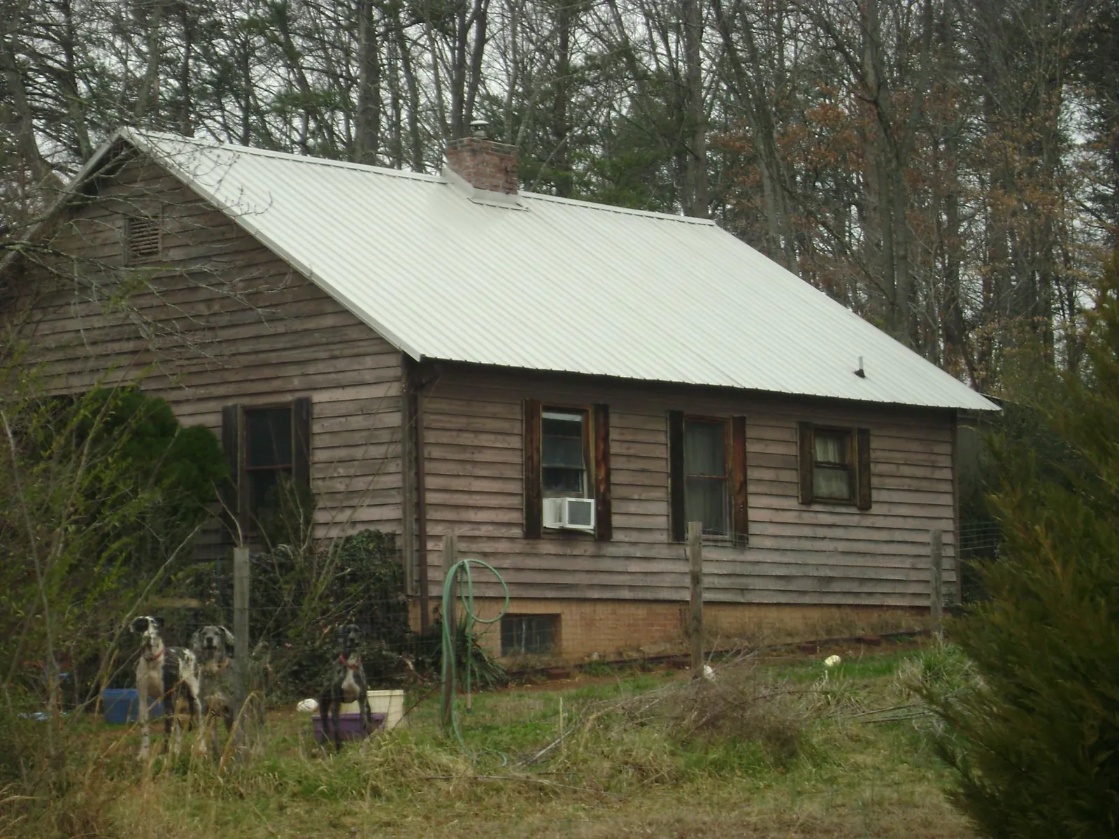 White metal roof on an old wood sided farmhouse, from a Metal Roof Installation job in Orofino